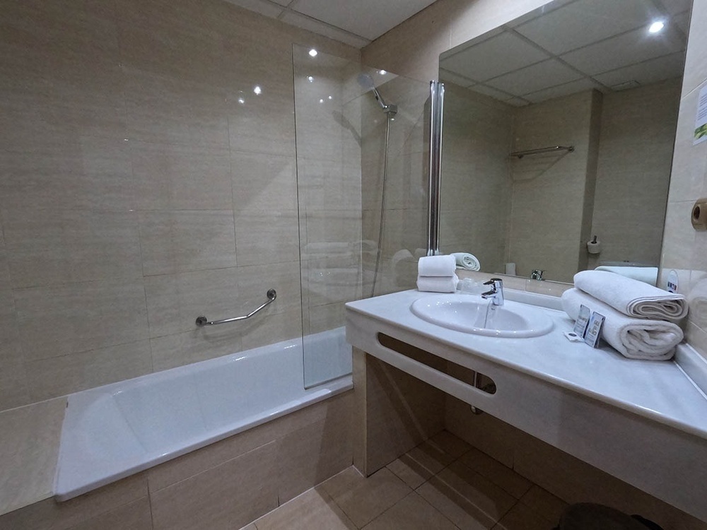 un baño con una bañera y un lavabo y un espejo