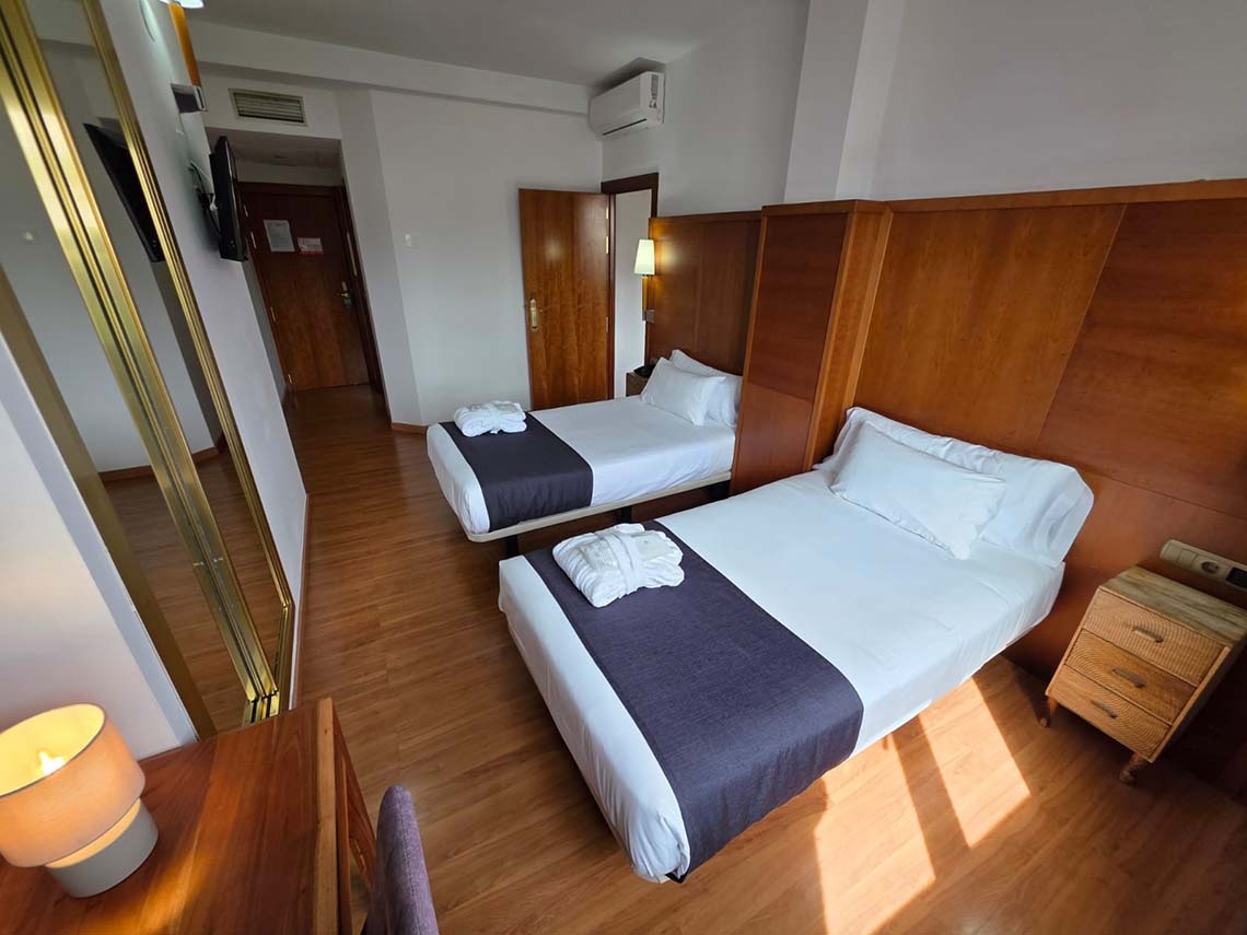 Habitación doble con dos camas y dos albornoces en Hotel Saylu.