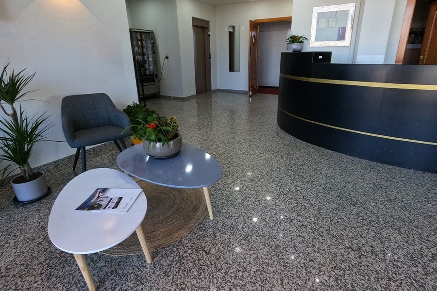 a waiting room with two tables and a black counter