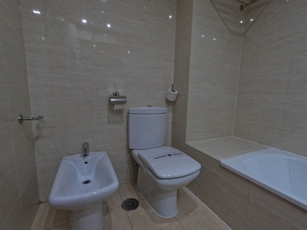 un baño con un inodoro y un lavabo y una bañera