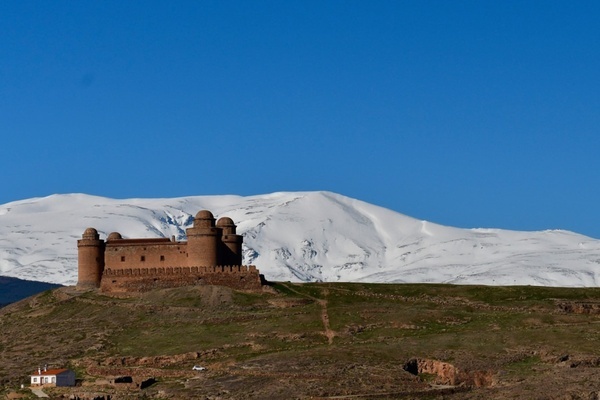 a silver car with a red tail light is parked in a parking garage