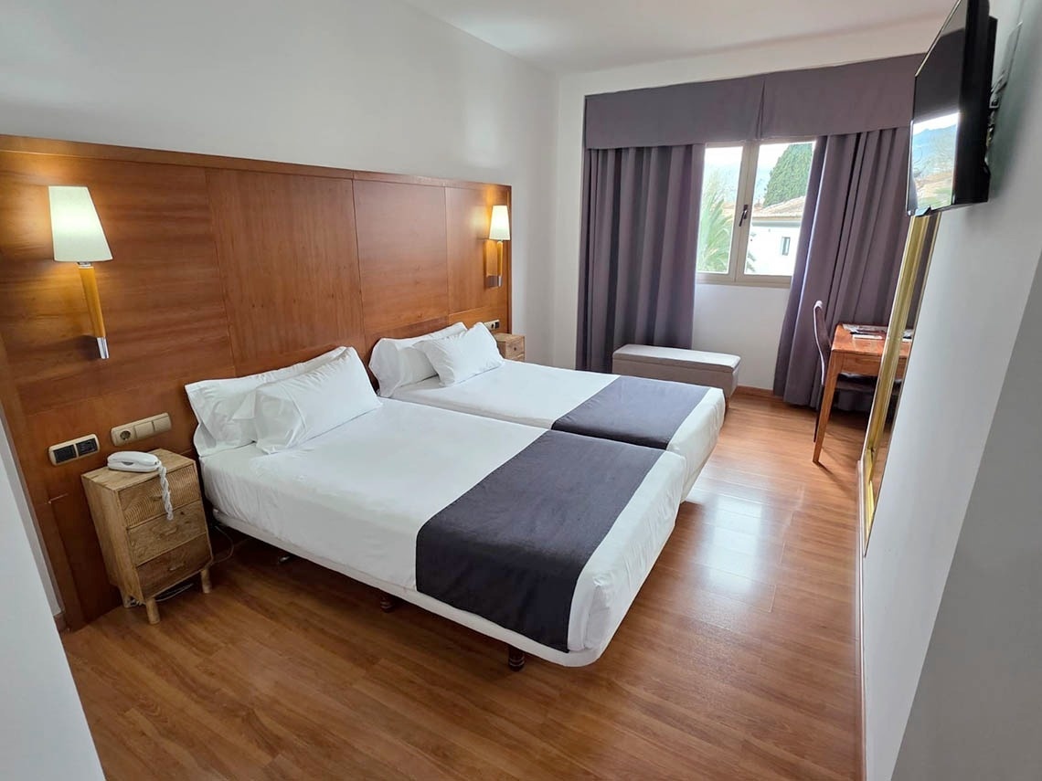 una habitación de hotel con una cama y una mesita de noche