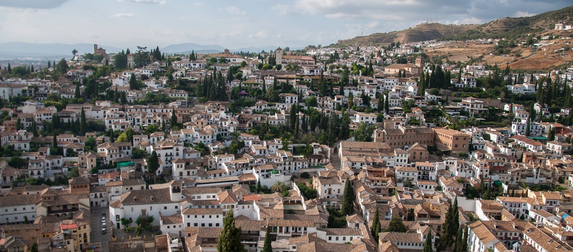 an aerial view of a city with white buildings and brown roofs