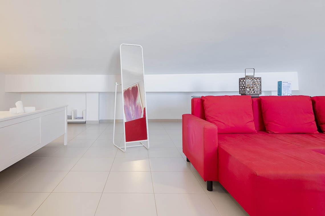 Leuchtend rotes Sofa im Sea You: Port Saplaya mit Spiegel und Deko.