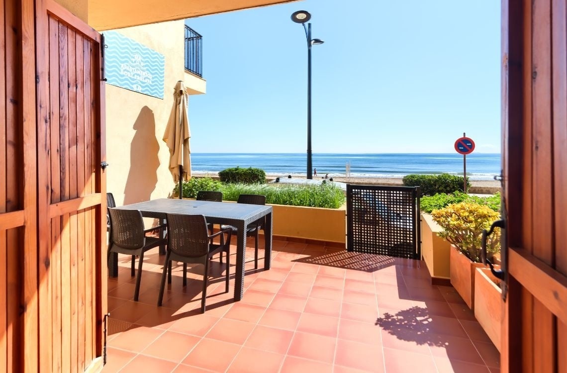 Terrazza con vista mare a Sea You: Port Saplaya, arredata con tavolo e sedie.