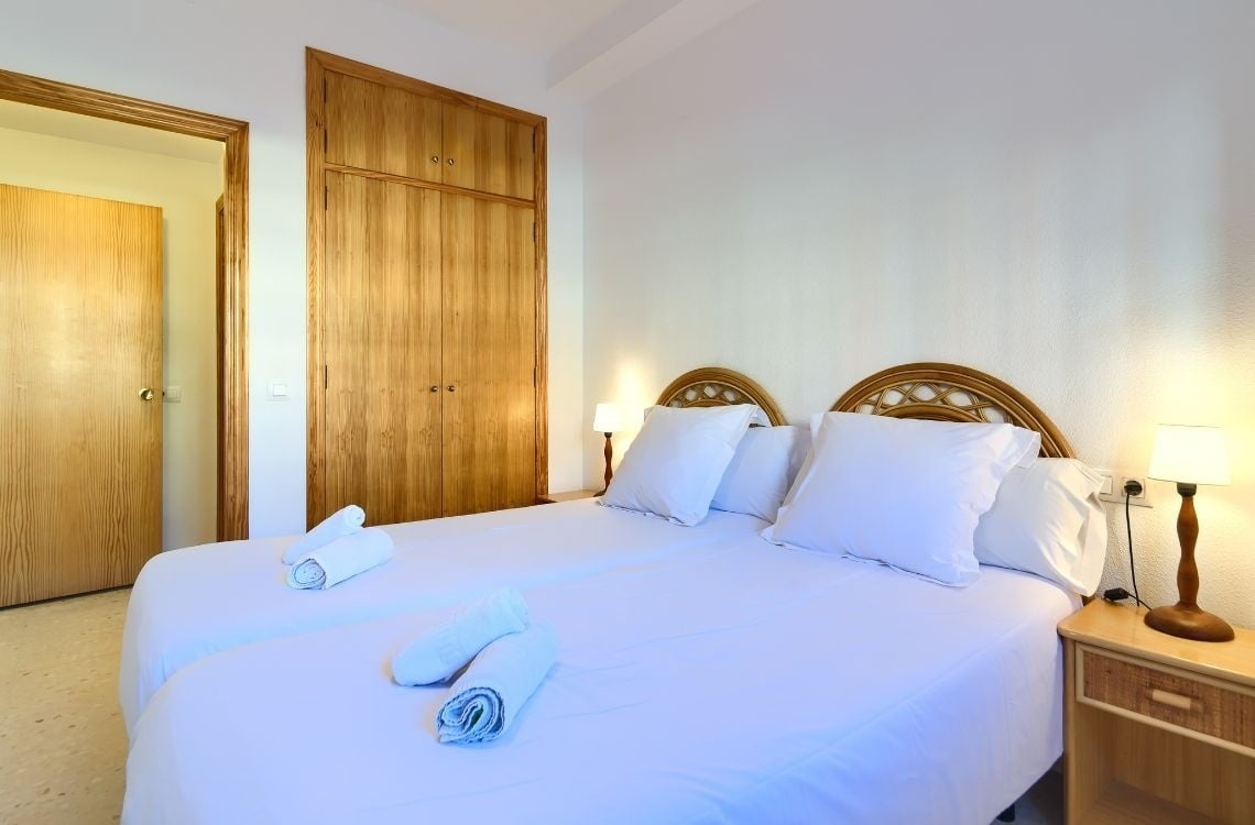 Camera vista della camera da letto di Sea You: Port Saplaya con letti gemelli e armadio in legno.