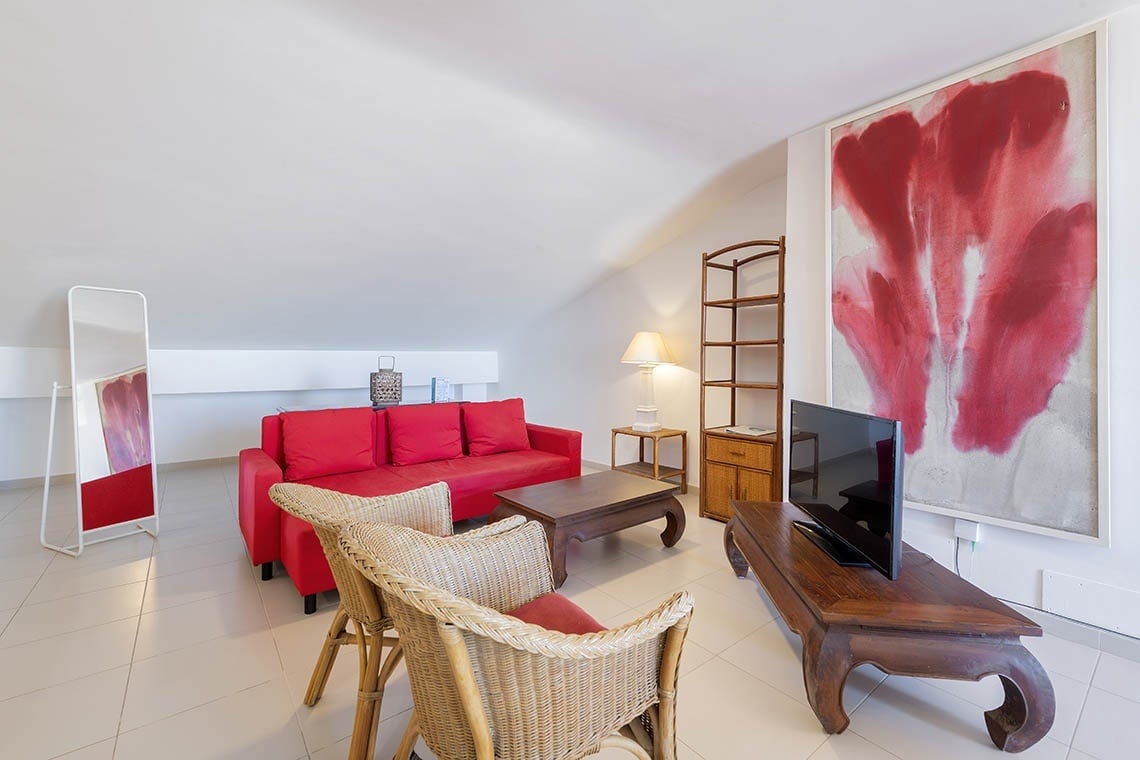Helles Wohnzimmer mit rotem Sofa und abstrakter Kunst in Sea You: Port Saplaya.
