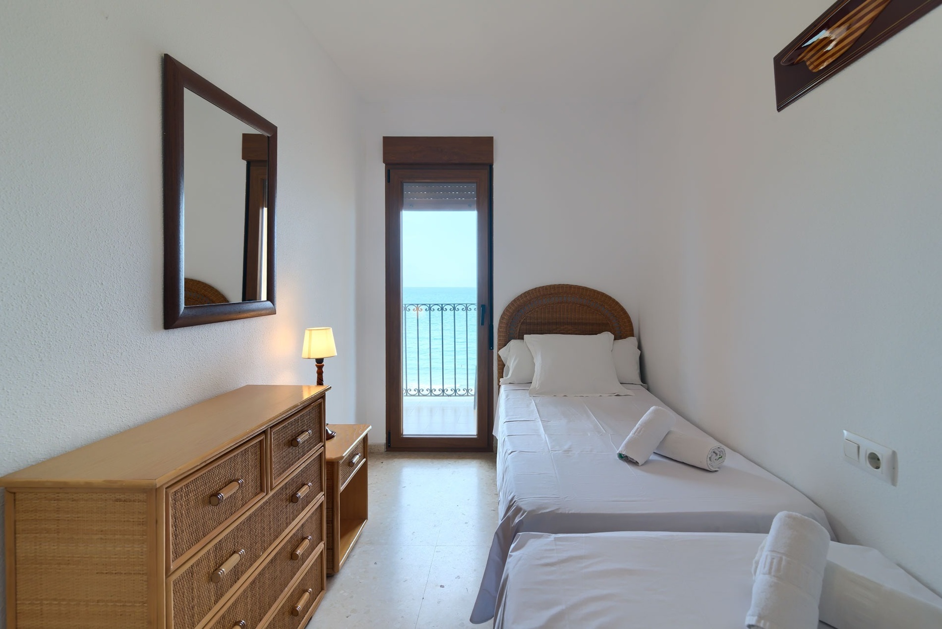 Salón y comedor de Sea You: Port Saplaya con sofá rojo, mesa y cuadros.