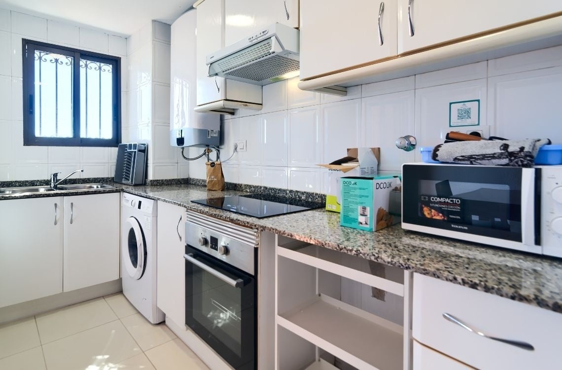Cucina funzionale con lavatrice e forno, parte di Sea You: Port Saplaya.