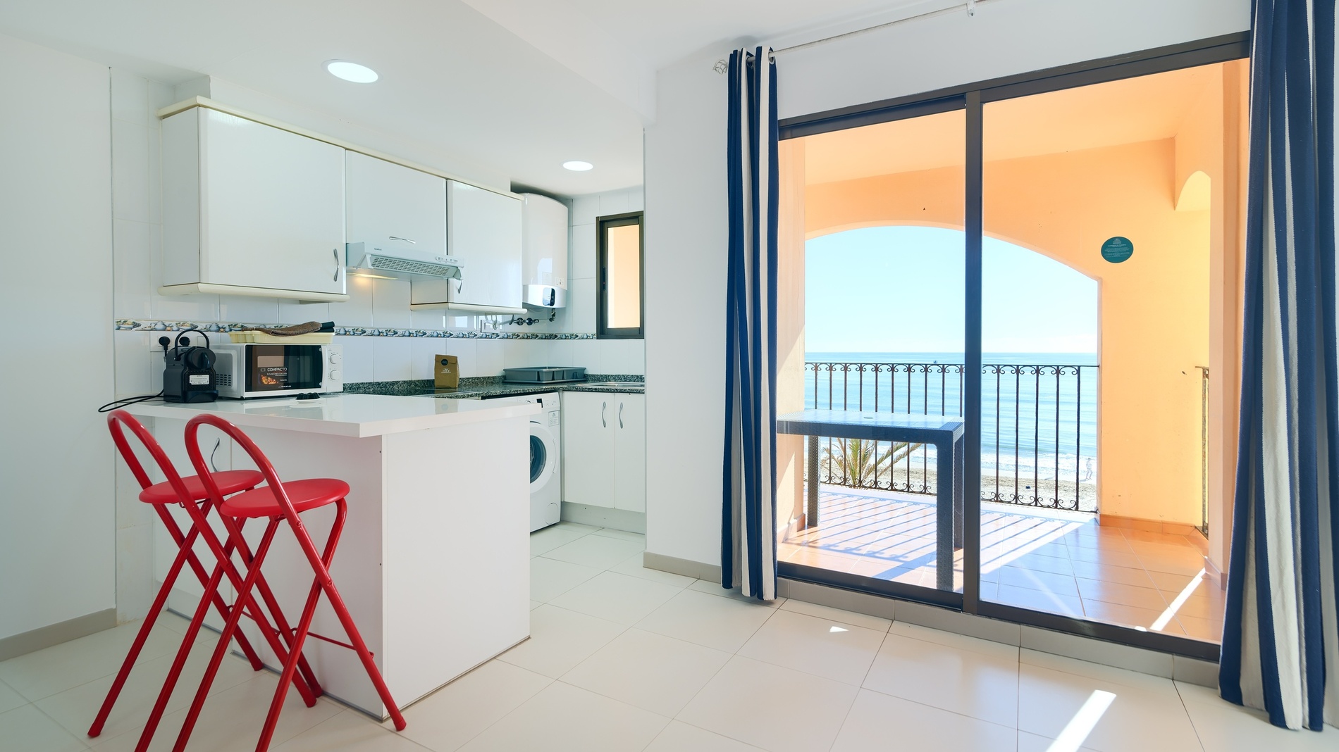 Comedor y sala de estar de Sea You: Port Saplaya con muebles de madera y ratán.