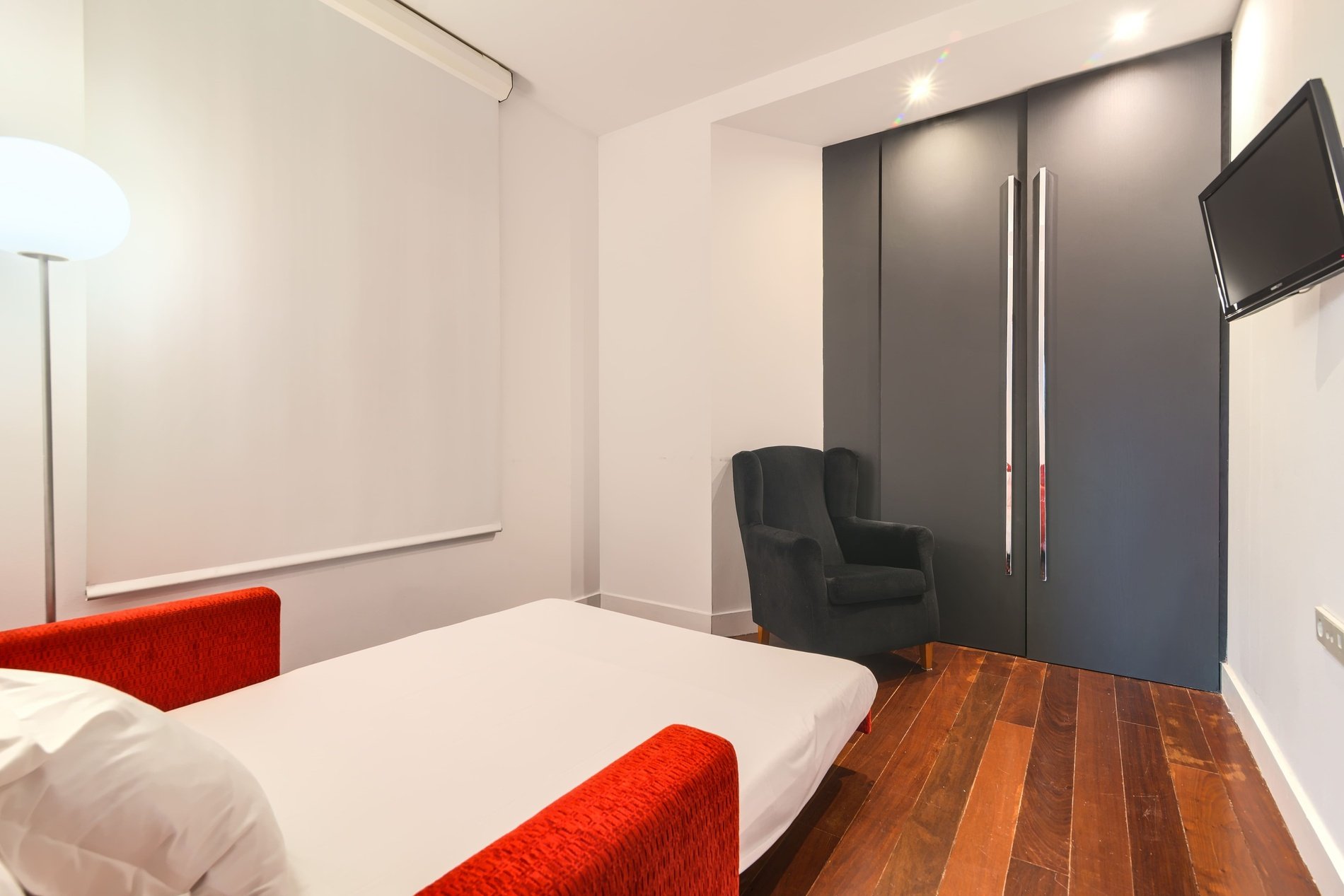 une chambre avec un lit , une chaise et une télévision