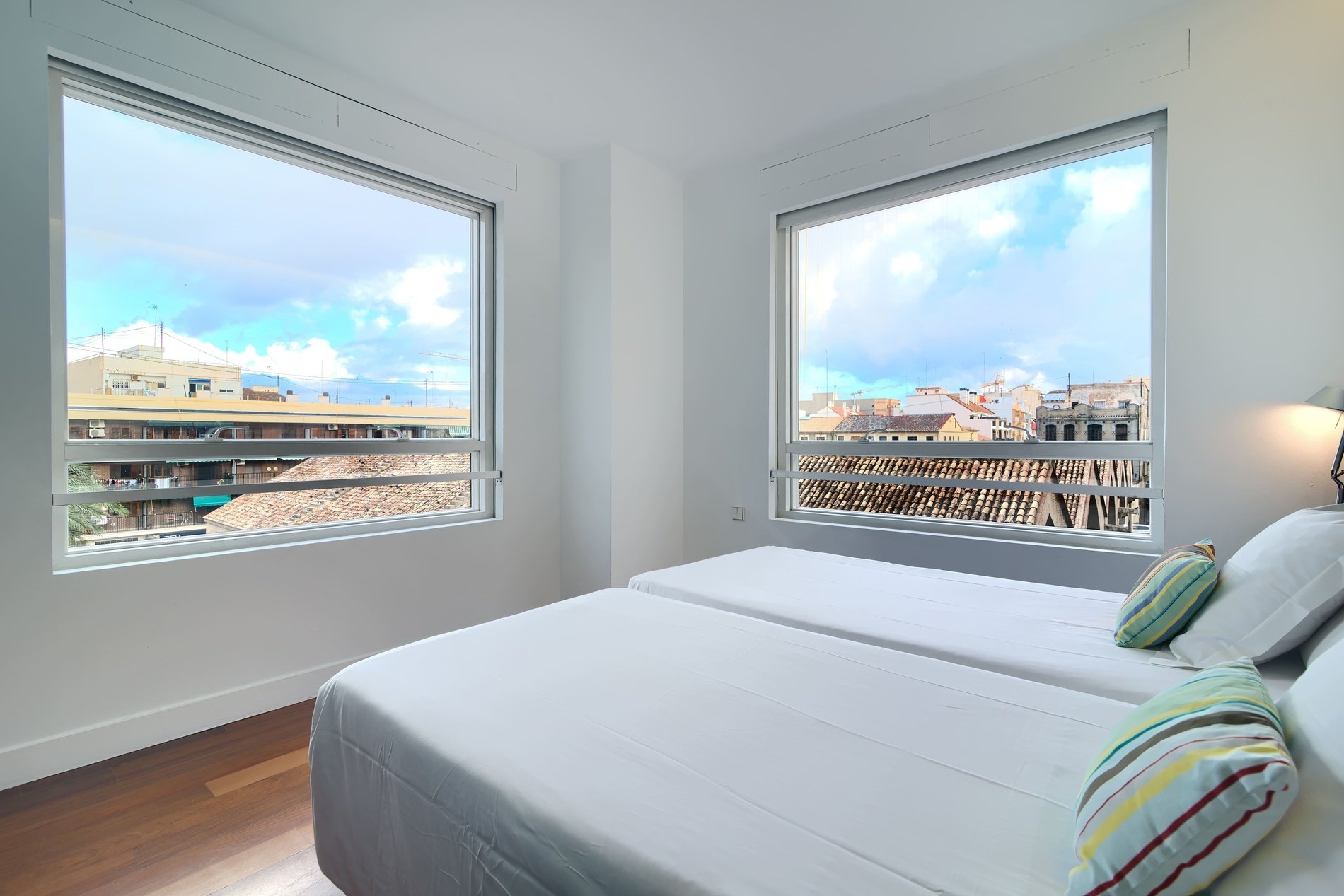 une chambre avec deux lits et une grande fenêtre
