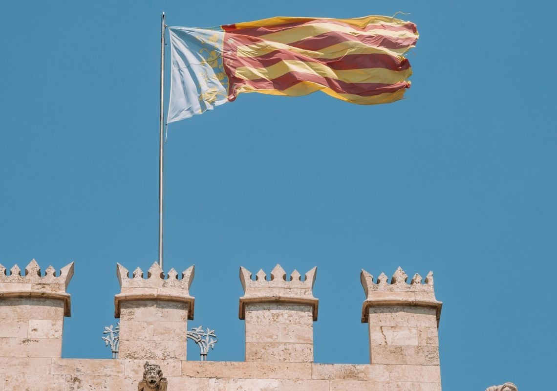 Drapeau flottant au-dessus d'un bâtiment historique, symbolisant l'importance de la chauve-souris à Valence | Hôtel Sea You Valence