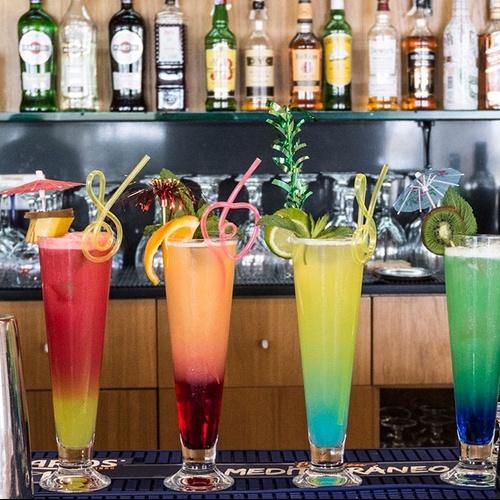 varios cócteles están sentados en un mostrador de bar