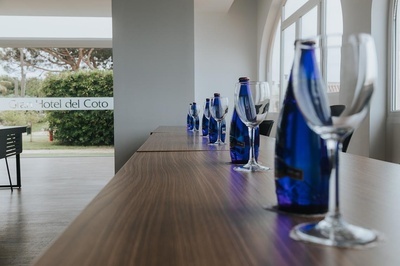 una mesa de madera con botellas y copas de vino en el hotel del coto - MICE