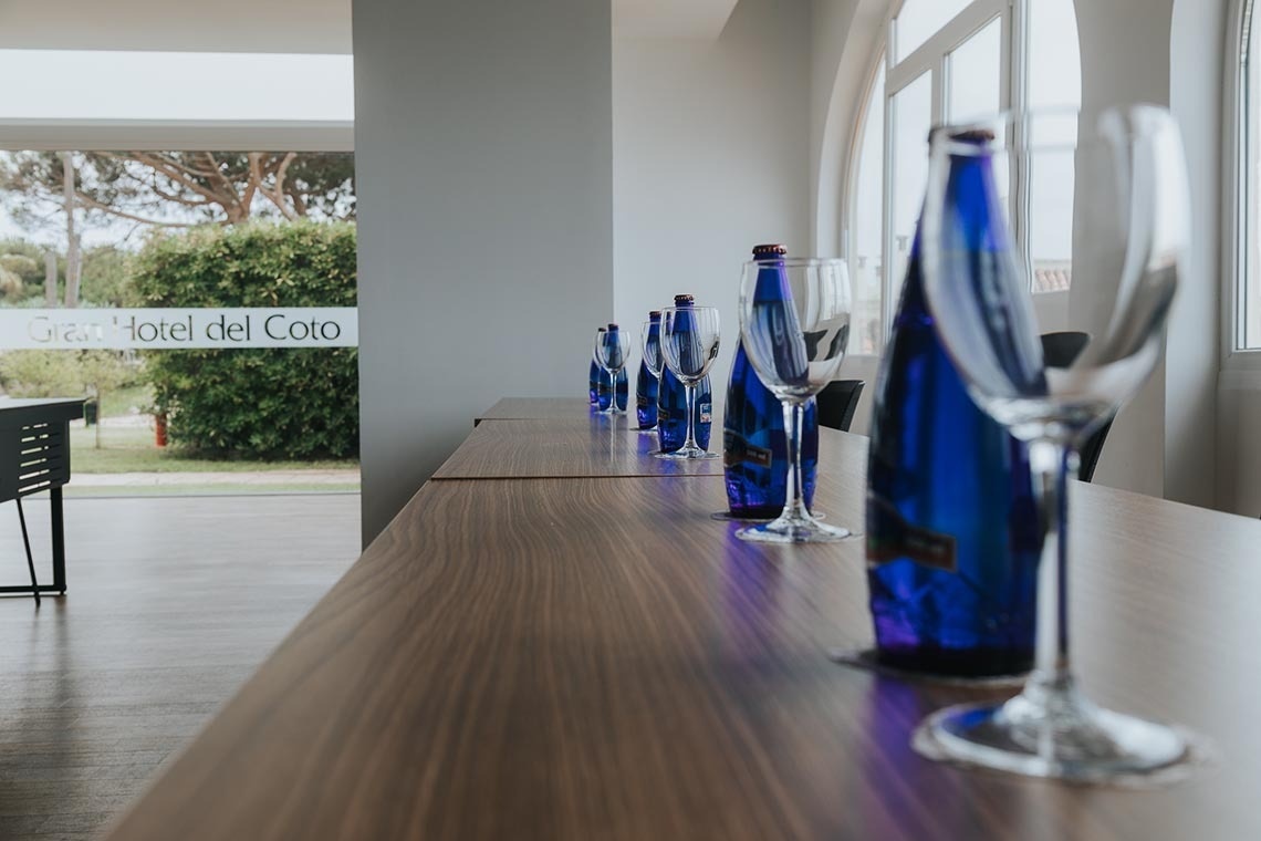 una mesa de madera con botellas azules y copas de vino