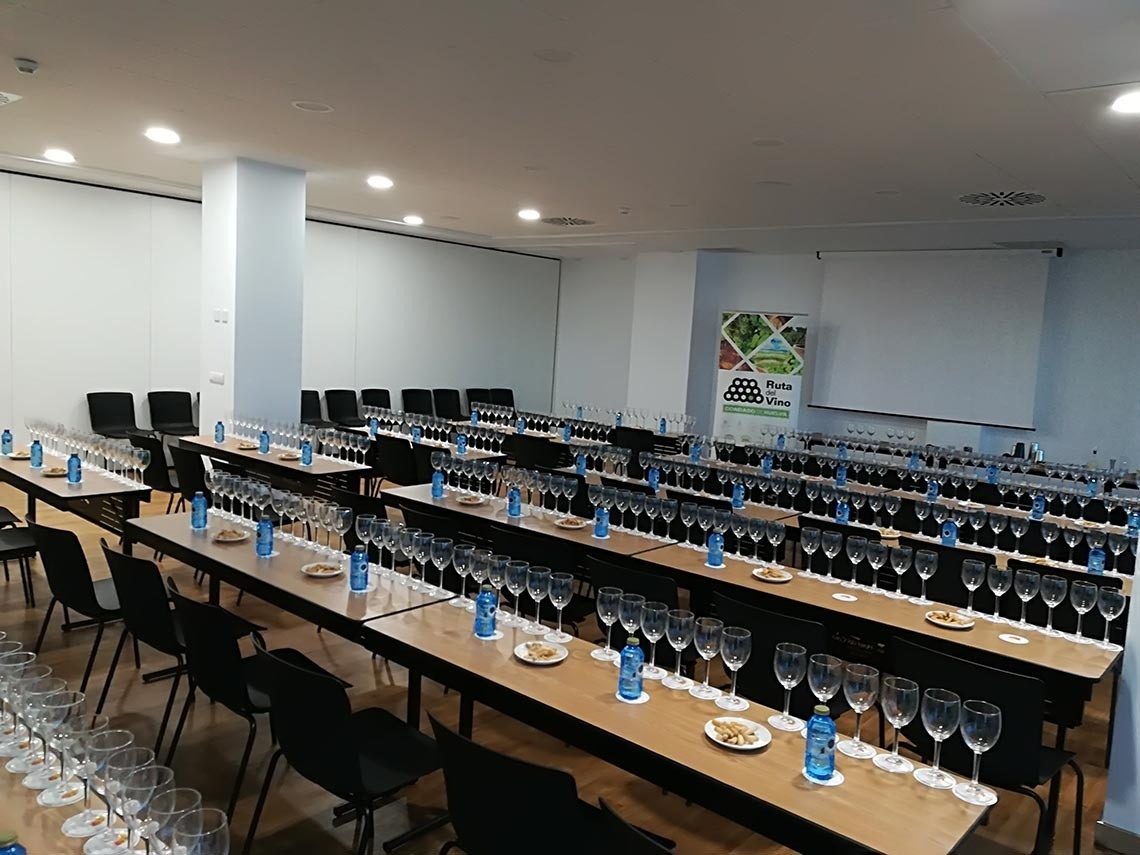 una habitación llena de mesas y sillas con copas de vino