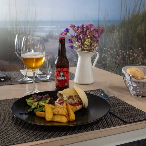 una mesa con un plato de comida y una botella de cocina
