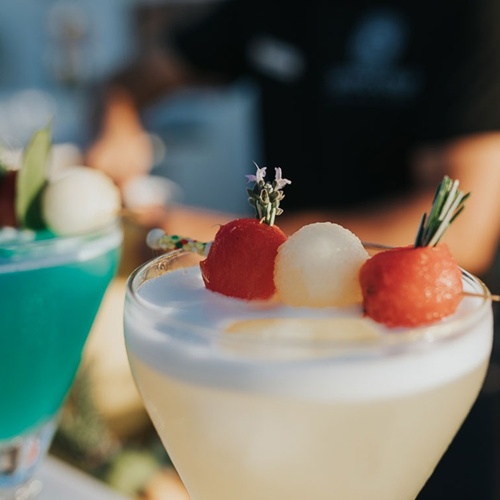 un primer plano de dos cócteles con frutas encima