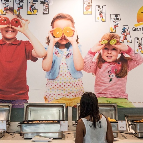 una niña se sienta frente a un buffet del gran hotel del coto