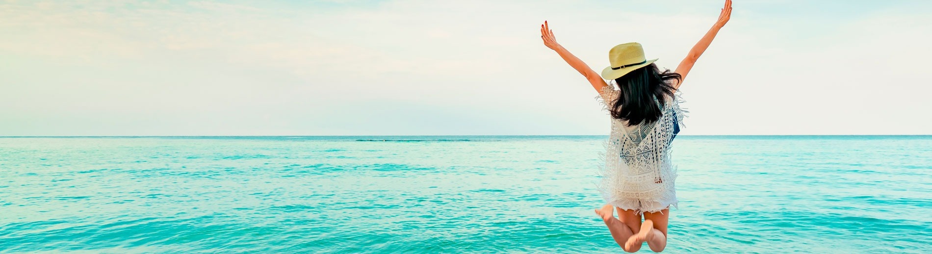 Person with hands up on the beach