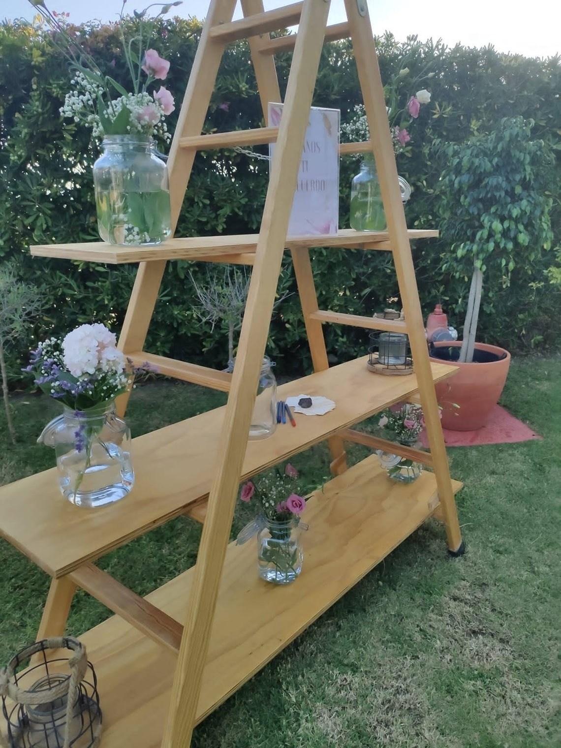 una escalera de madera está decorada con jarrones y flores