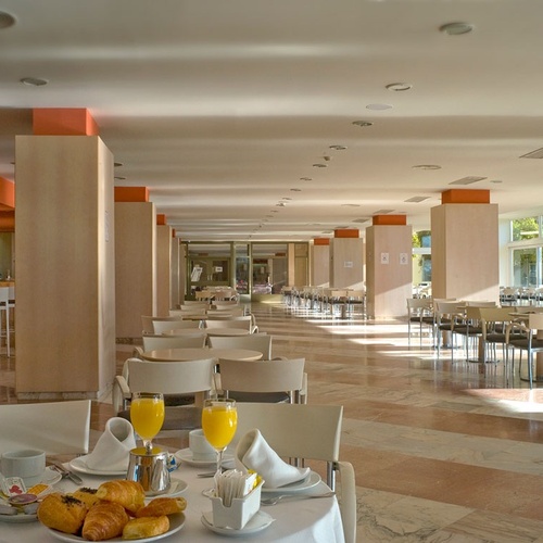 un restaurante con mesas y sillas llenas de comida y bebidas