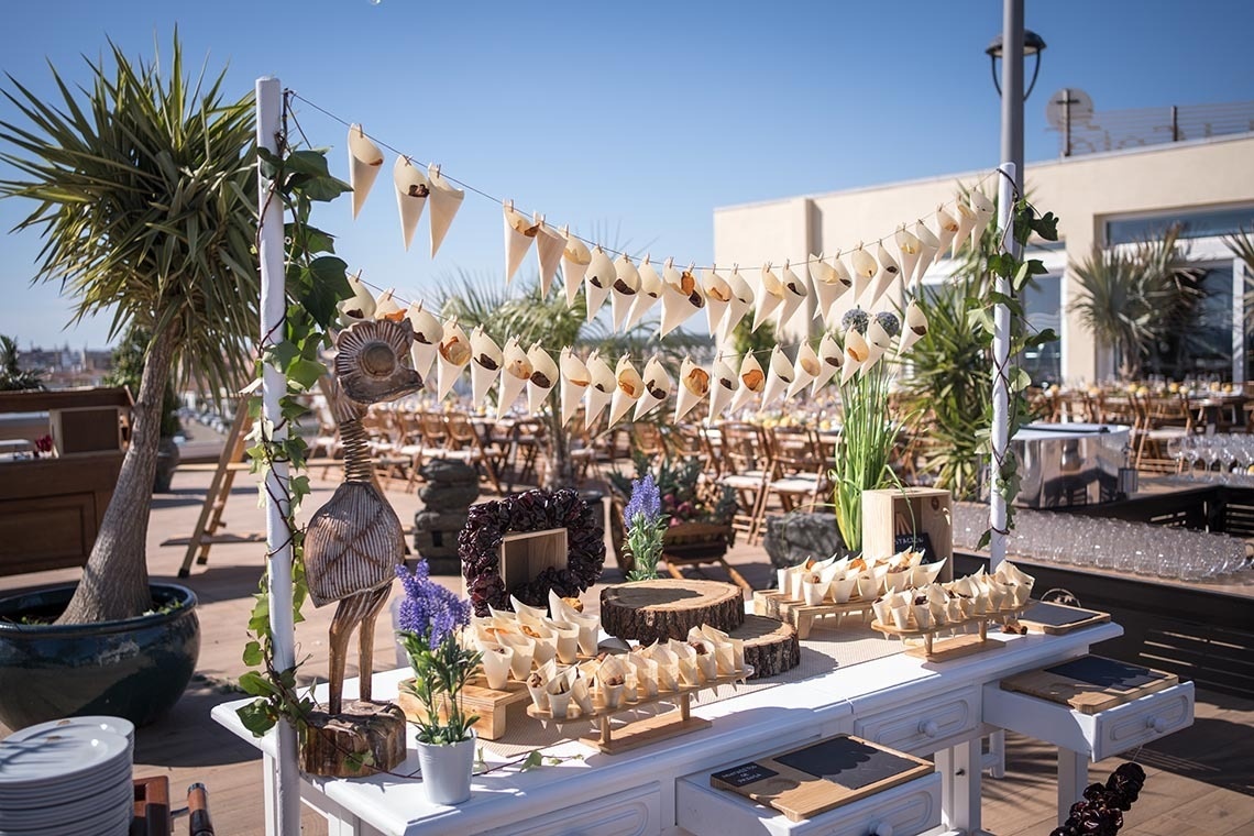 una mesa blanca está decorada con conos de papel y flores