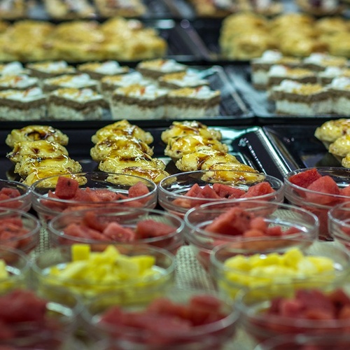 un montón de tazones de fruta y pasteles en un mostrador