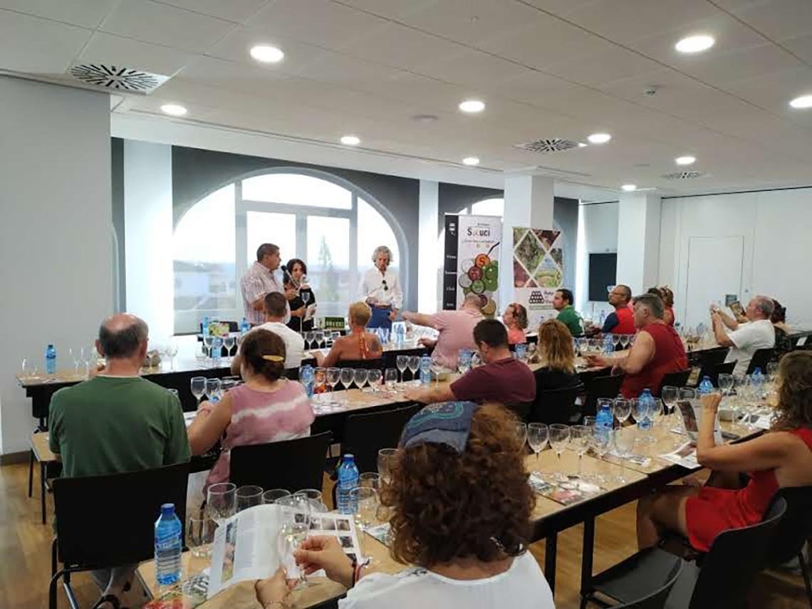 un grupo de personas están sentadas en mesas con copas de vino