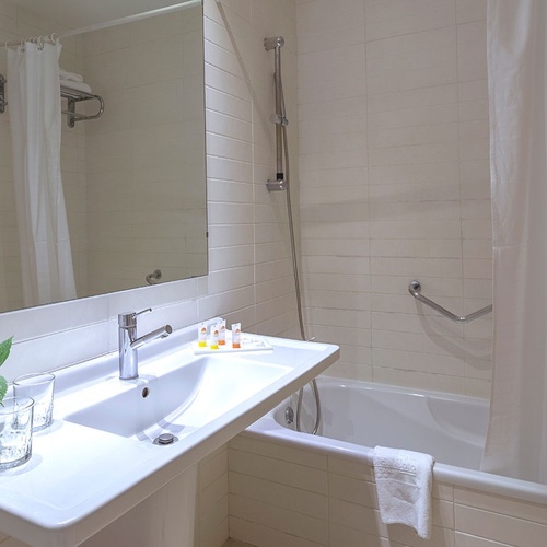 un baño con un lavabo y un secador de pelo