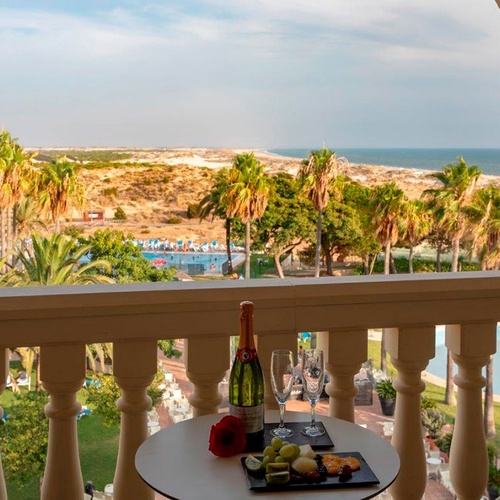 una mesa en un balcón con una botella de champán y dos copas