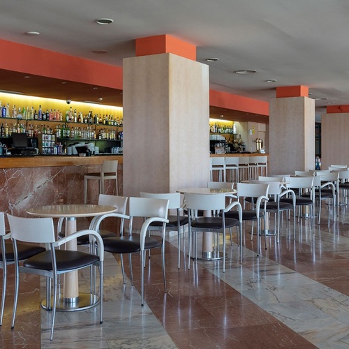 una larga fila de mesas y sillas frente a un bar