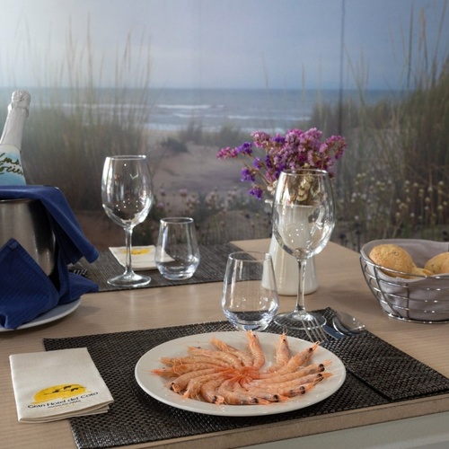 una mesa con un plato de camarones y una botella de cava