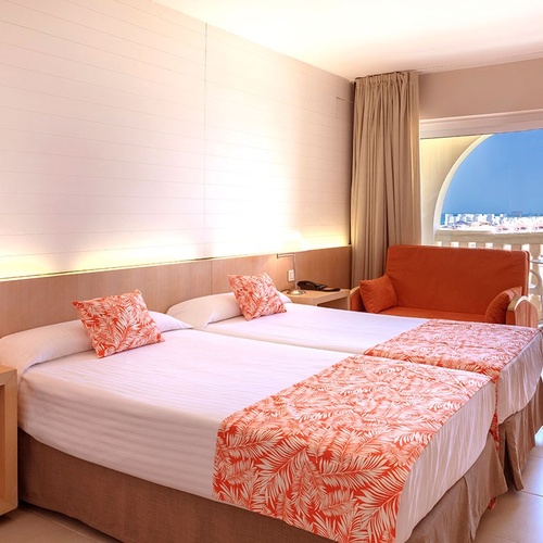 una habitación de hotel con dos camas y una silla