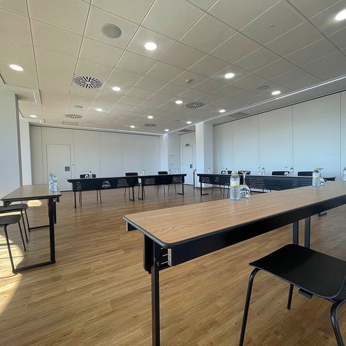 una sala de conferencias con mesas y sillas y una puerta abierta