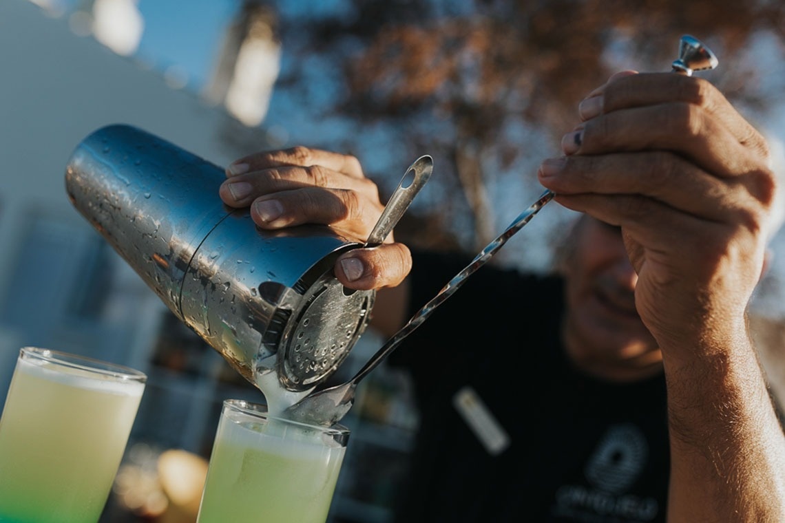 um barman está derramando um coquetel em um copo