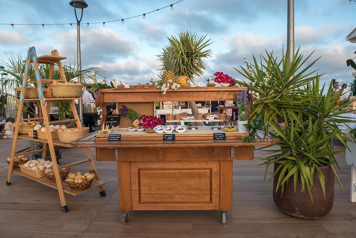 un carrito de madera con comida y bebidas en él