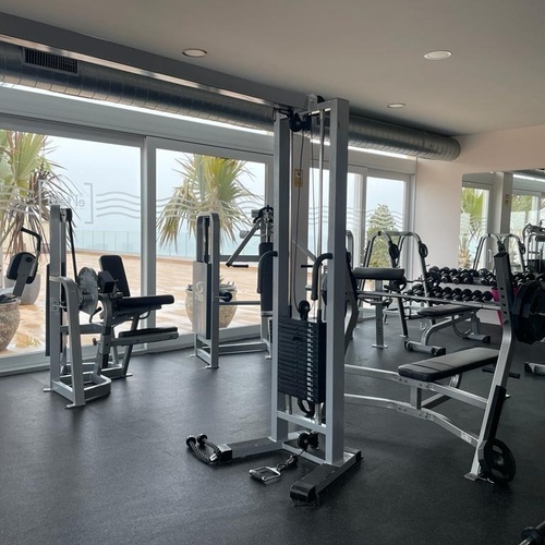 un gimnasio con muchos aparatos y una gran ventana