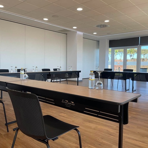 una habitación vacía con mesas y sillas en forma de u