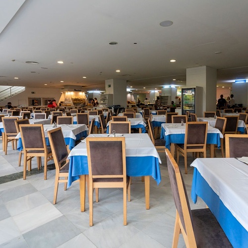 un restaurante lleno de mesas y sillas con manteles azules