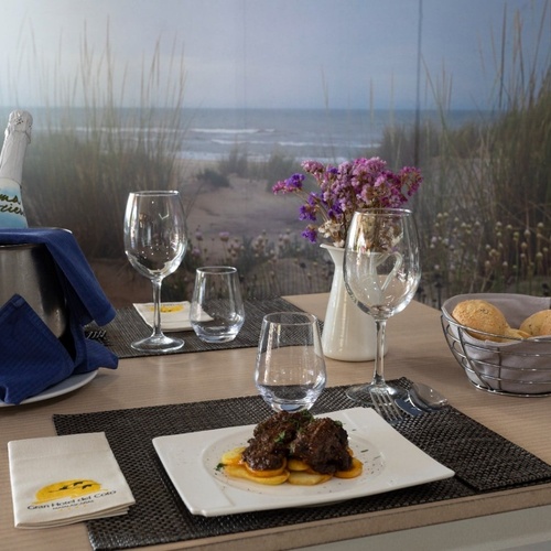 una mesa con un plato de comida y una botella de cava