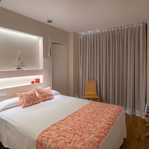 una habitación pequeña con una cama y una televisión