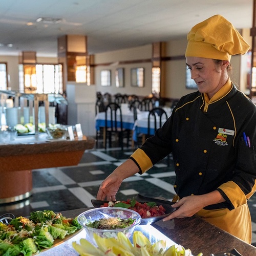 un chef prepara una ensalada en un restaurante