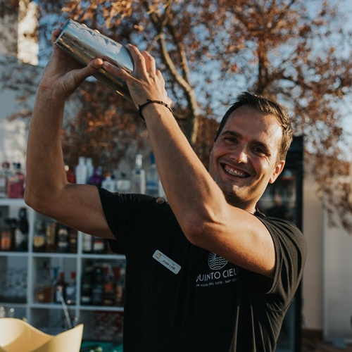un hombre con una camisa negra que dice junto al cielo mezcla un cóctel