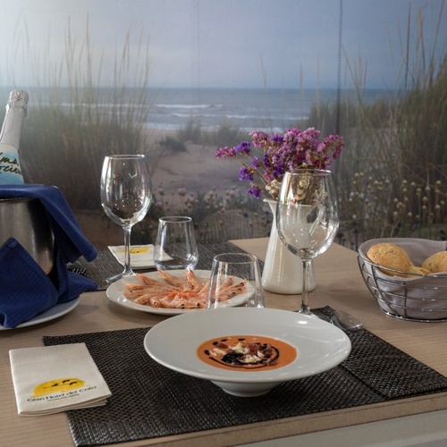 una mesa con platos de comida y una botella de cava las rocas