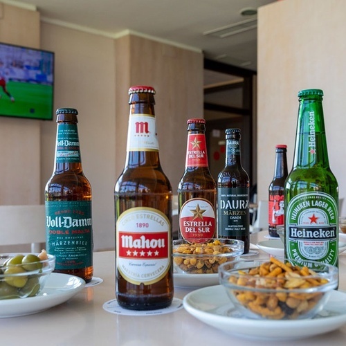 una variedad de botellas de cerveza están sobre una mesa