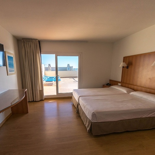 una habitación de hotel con dos camas y una televisión