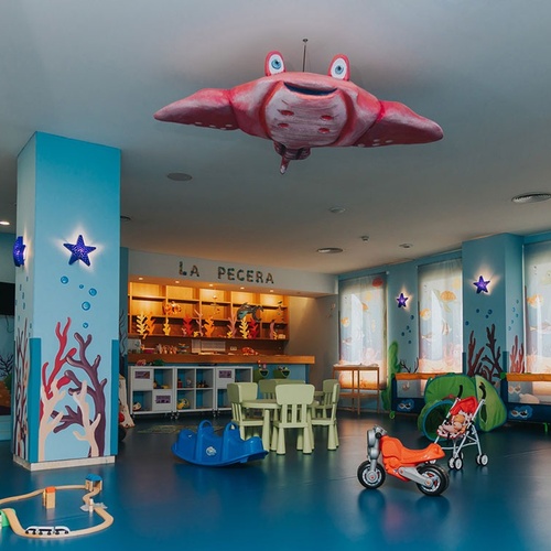 una sala de juegos para niños con la pecera en la pared