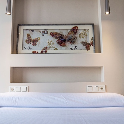 una cama con una pintura de mariposas encima de ella